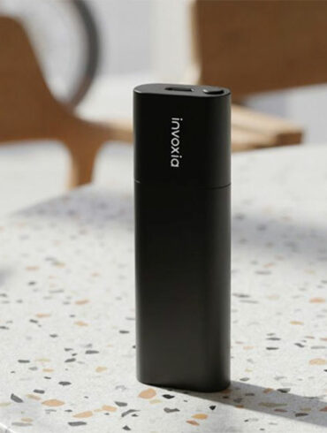 Le traceur GPS Invoxia Tracker Pro Max posé sur une table, format compact noir