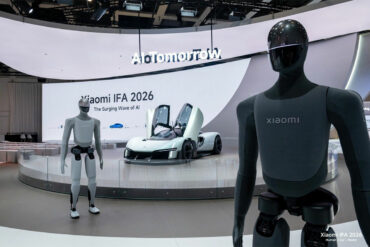 Vue large du stand Xiaomi avec la signature « Innovation for Everyone » et les robots humanoïdes, pour montrer l'ampleur de la présence